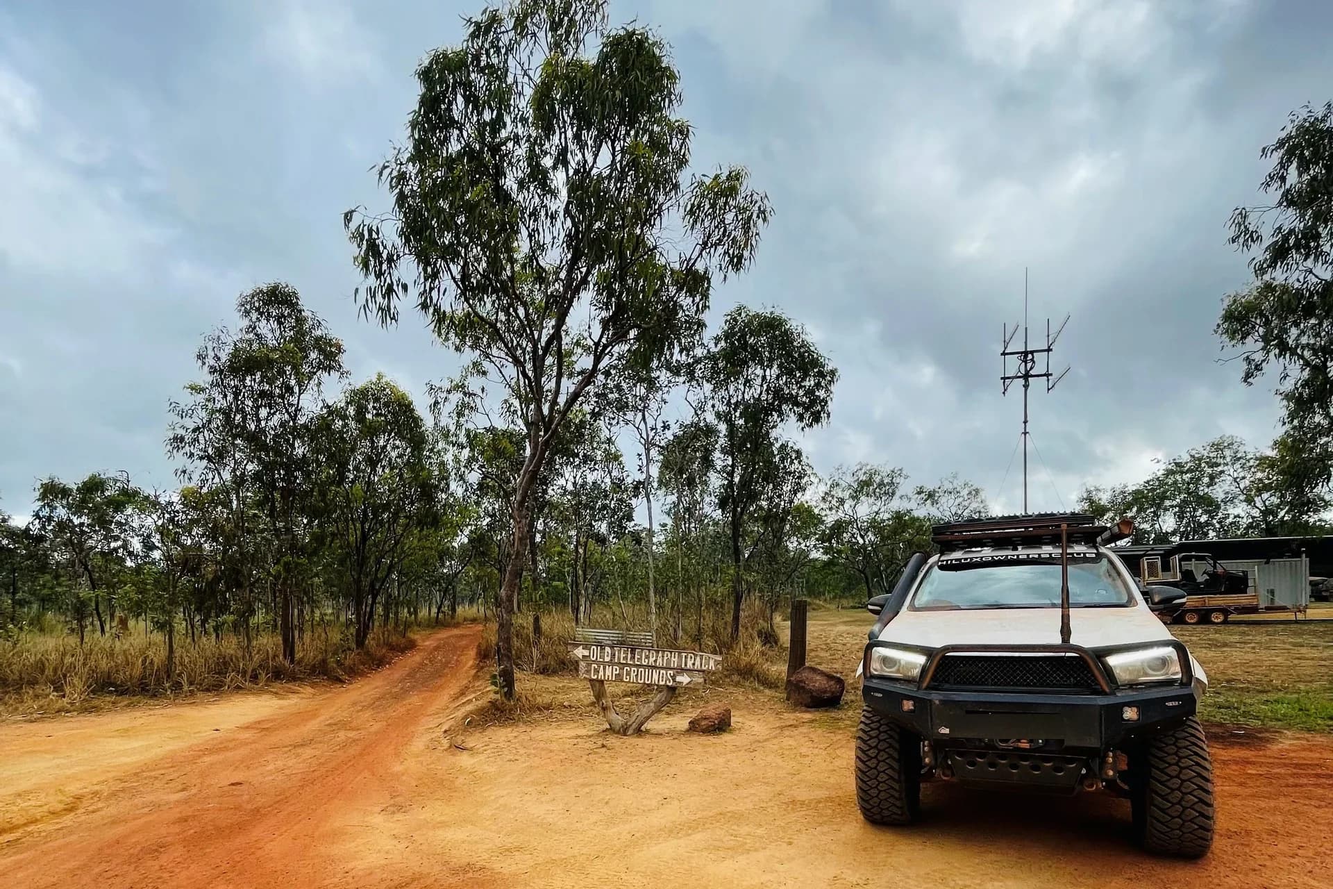 A Hilux at the start of the Old Telegraph Track, a signpost pointing to the track and camp grounds.